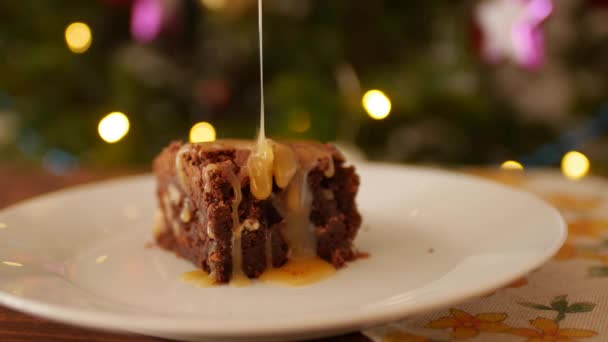 En fyrkantig bit choklad Brownie på en tallrik, hällde sträng saltad karamell. — Stockvideo