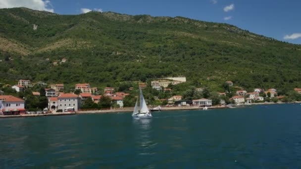 Tivat, Montenegro - 15 de maio de 2016: Um pequeno iate à vela está navegando ao longo da Baía de Kotor, em Montenegro. Regata marinha de iates à vela . — Vídeo de Stock