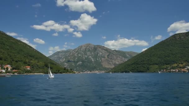 Tivat, Montenegro - 15 de maio de 2016: Um pequeno iate à vela está navegando ao longo da Baía de Kotor, em Montenegro. Regata marinha de iates à vela . — Vídeo de Stock