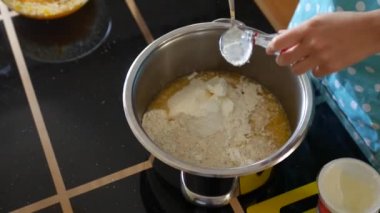 Kadın Aşçı hamura kaşık dolusu votka ekler, geleneksel Paskalya pastası için hamur hazırlar, Panettone - Milano Noel tatlısı, Stollen - geleneksel Alman hamur işleri. Hamur işi yapma süreci.