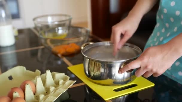 Woman chef pours dry yeast into milk in a pan and stirs with a fork to dissolve. — Stock Video