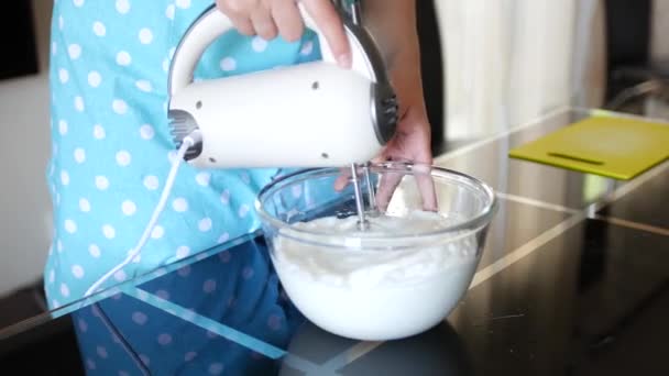 Kvinna kock blandar äggvita med en mixer i ett glas transparent skål till ett tillstånd av vitt luftigt skum. — Stockvideo