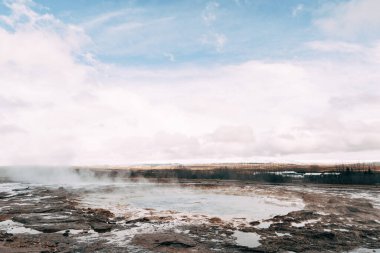 İzlanda 'nın güneybatısındaki Gayzer Vadisi. Meşhur turist eğlencesi Gaysir. Jeotermal bölge Haukadalur. Laugarfjall tepesinin yamaçlarında Strokkur gayzerleri.