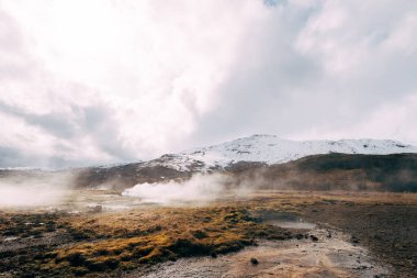 İzlanda 'nın güneybatısındaki Gayzer Vadisi. Meşhur turist eğlencesi Gaysir. Jeotermal bölge Haukadalur. Laugarfjall tepesinin yamaçlarında Strokkur gayzerleri.