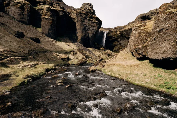 Cesta k vodopádu Kvernufoss na jihu Islandu, na Golden Ring. Horská řeka v rokli s mechem a žlutou trávou. — Stock fotografie