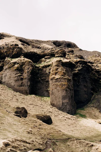 Вершина скалистых гор Исландии, подножие горы покрыто желтой травой и омомой . — стоковое фото