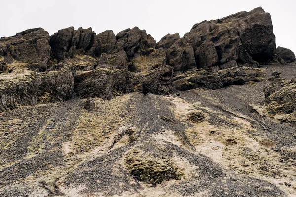 En närbild av strukturen på bergen på Island. Basalt vulkaniska stenar, puffstenar täckta med mossa. — Stockfoto