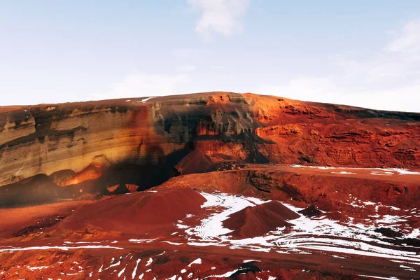 Paisajes marcianos en Islandia. El cráter rojo del volcán Seydisholar. La cantera de la minería del suelo rojo. Nieve blanca yace en suelo rojo . — Foto de Stock