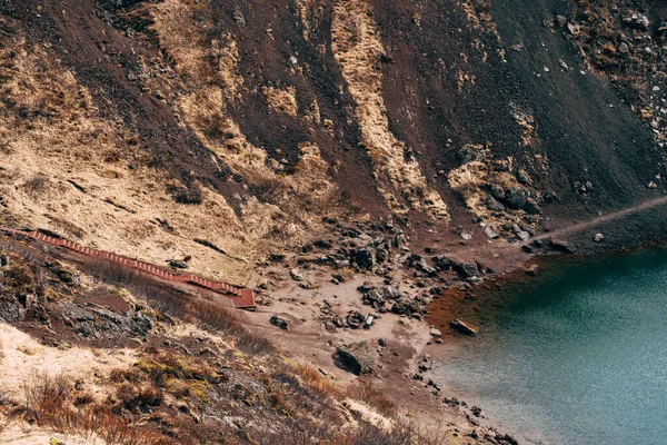 Lake Kerid är en kratersjö eller vulkanisk sjö, i kratern av en vulkan på Island. Ovanlig röd jord, liknande det marsianska landskapet. Trappor till botten av sjön. — Stockfoto