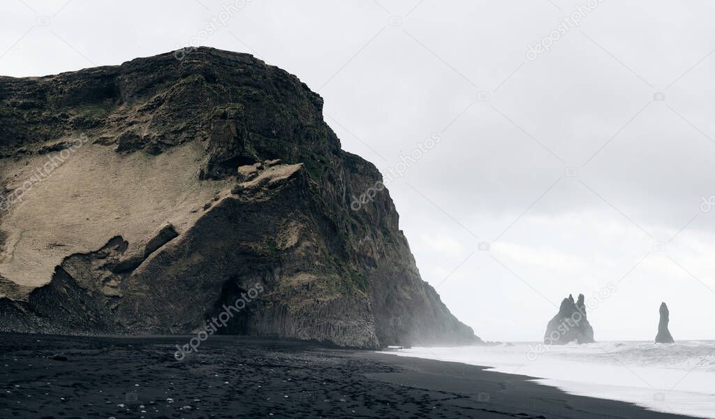 Black Beach Vik in Iceland. Waves of the Atlantic Ocean. Basalt pillars on the coast.