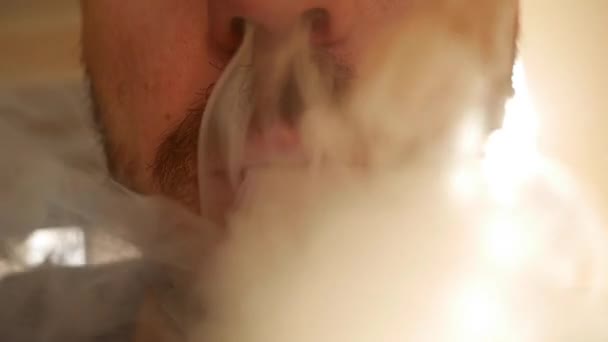 Homme barbu fumant une cigarette électronique. Vaper. Fumée générée par la cigarette. Concept de fumeur du futur, soins de santé ou maladies causées par les cigarettes électroniques — Video