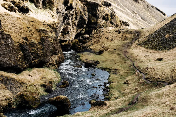 O rio da montanha flui para o desfiladeiro entre as montanhas. Não muito longe da cachoeira Kvernufoss na Islândia . — Fotografia de Stock