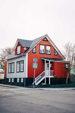 İzlanda 'nın başkenti Reykjavik' te sokakta gri çatılı kırmızı ve beyaz bir ev..