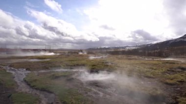 İzlanda 'nın güneybatısındaki Gayzer Vadisi. Meşhur turist eğlencesi Gaysir. Jeotermal bölge Haukadalur. Laugarfjall tepesinin yamaçlarında Strokkur gayzerleri.