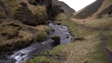 İzlanda 'nın dağları arasında tehlikeli bir vadide, sığ ve hızlı bir dağ nehri..