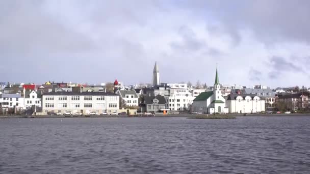 Gebouwen aan de oever van het meer van Tjodnin, in Reykjavik, de hoofdstad van IJsland. — Stockvideo