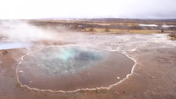 Valle de Geyser en el suroeste de Islandia. La famosa atracción turística Geysir. Zona geotérmica Haukadalur. Géiser Strokkur en las laderas de Laugarfjall colina . — Vídeo de stock