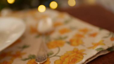 Tabakta kare bir parça çikolatalı kek, ahşap bir arka planda, sarı çiçekli bir peçete ve eski bir melchior kaşığı. Altın tuzlu karamel yavaşça süzülür.. 