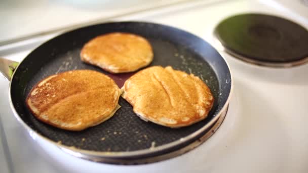 Drie roodgouden pannenkoeken in een koekenpan, een close-up, witte stoom. — Stockvideo