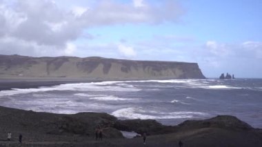 Kara kumsalda fırtınalı, kasvetli bir gün. İzlanda, Avrupa 'nın güneyinde Vik Reynisfjara, Atlantik Okyanusu' nda büyük dalgalar.