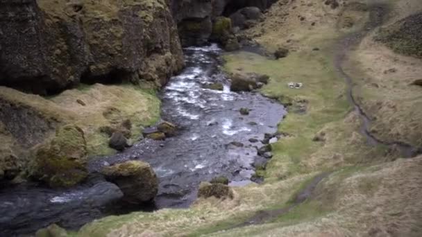 Rio de montanha raso rápido, em um desfiladeiro perigoso entre as montanhas na Islândia . — Vídeo de Stock