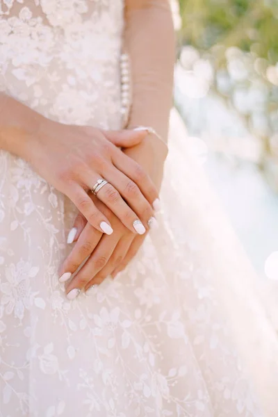 Primer plano de las manos de las novias con un anillo de bodas sobre un fondo de vestido de crema. Bellas artes foto de la boda en Montenegro, Perast . — Foto de Stock