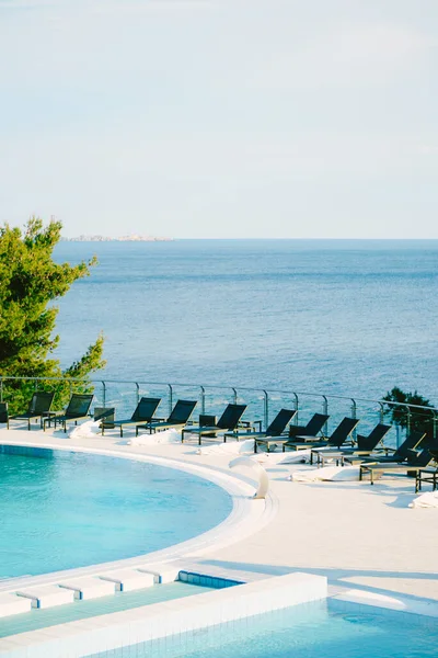 Lotes de espreguiçadeiras perto da piscina, em um hotel perto do mar . — Fotografia de Stock