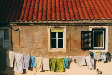 Renkli havlular, pencereler arasında, binanın ön cephesinde bir iple kurutuluyor..