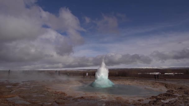 İzlanda 'nın güneybatısındaki Gayzer Vadisi. Meşhur turist eğlencesi Gaysir. Jeotermal bölge Haukadalur. Turistler, Laugarfjall tepesinin yamaçlarındaki Strokkur gayzerinin patlamasına bakıyorlar.. — Stok video