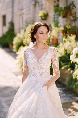 Karadağ 'da sanat eseri bir düğün fotoğrafı, Perast. Eski bir sokakta dantelli beyaz elbiseli bir gelinin portresi.