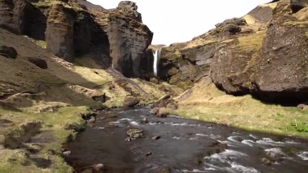 Vägen till Kvernufoss vattenfall på södra Island, på Golden Ring. Berg flod i en ravin med mossa och gult gräs. — Stockvideo