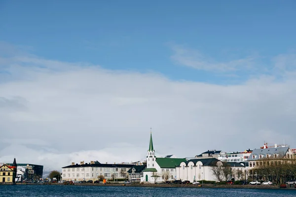 Edificios en la orilla del lago Tjodnin, en Reikiavik, la capital de Islandia . — Foto de Stock