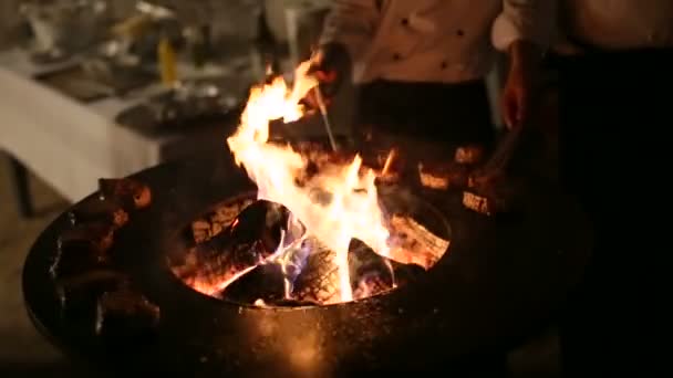 Kocken kontrollerar temperaturen inne i grillad köttbiff. Sous-kocken vänder kulinariska pincetter stack. Det nya, vackra sättet att laga mat och underhålla utomhus. Firepit, grill och skulptur. — Stockvideo