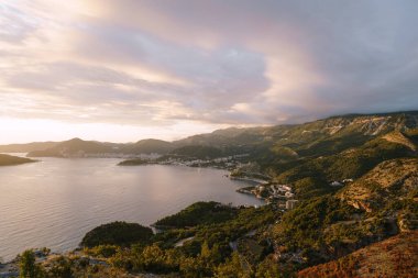 Budvan Sahili. Karadağ 'ın Adriyatik kıyısındaki dağlar ve şehirler gün batımında.