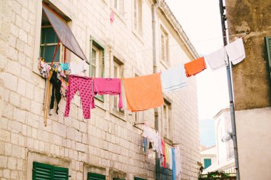 Giysiler iki bilgi arasındaki ipte kurumuş..