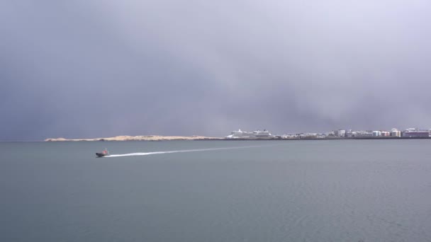 Cruiseschepen afgemeerd in de haven van Reykjavik, de hoofdstad van IJsland. Een motorboot zwemt snel door de zee. — Stockvideo