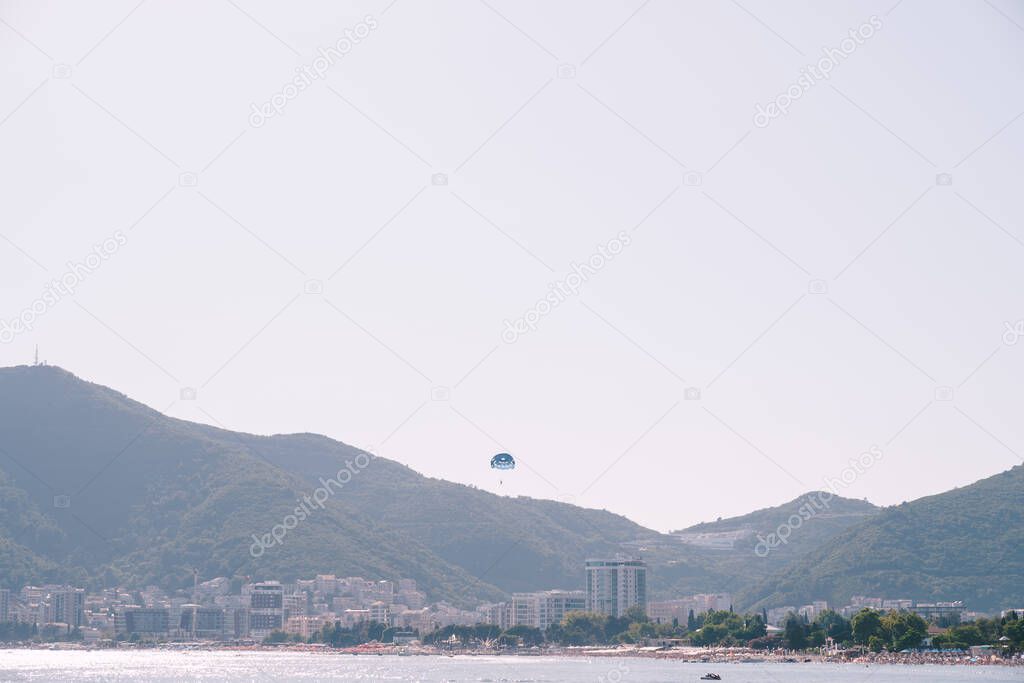 Entertainment for tourists - skydivers ride a boat on the sea in Budva, Montenegro.