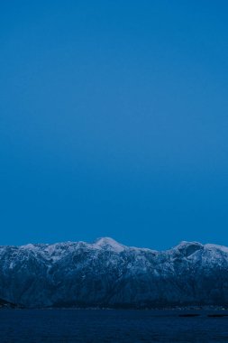Karadağ 'ın Boka Kotorska kentinde gece karlı dağ zirveleri. 