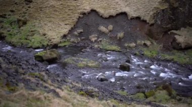 İzlanda 'nın dağları arasında tehlikeli bir vadide, sığ ve hızlı bir dağ nehri..