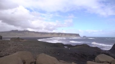 Kara kumsalda fırtınalı, kasvetli bir gün. İzlanda, Avrupa 'nın güneyinde Vik Reynisfjara, Atlantik Okyanusu' nda büyük dalgalar.