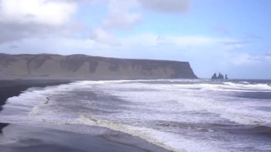 Kara kumsalda fırtınalı, kasvetli bir gün. İzlanda, Avrupa 'nın güneyinde Vik Reynisfjara, Atlantik Okyanusu' nda büyük dalgalar.
