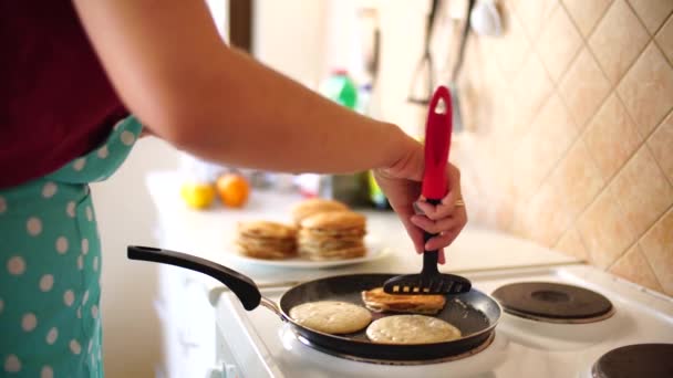 Le mani di donne con una spatola girano frittelle in una padella per friggere. — Video Stock