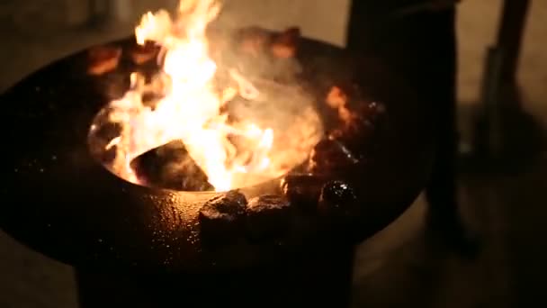 O chef rola a carne na torradeira com pinças. Bife de carne está sendo preparado em uma grade ao ar livre de ferro de aço redondo com uma placa de cozinhar e uma fogueira aberta no meio . — Vídeo de Stock