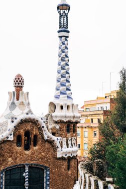 Barselona 'daki Park Guell' in merkezi girişi. Zencefilli kurabiye evleri. Uzun kuleli bir ev.