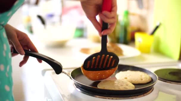 Una cocinera lanza una espátula de panqueques en una sartén . — Vídeos de Stock