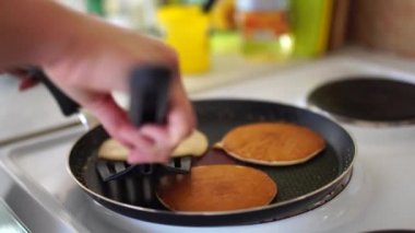 Spatulalı kadın eli kızartma tavasında krep yapıyor..