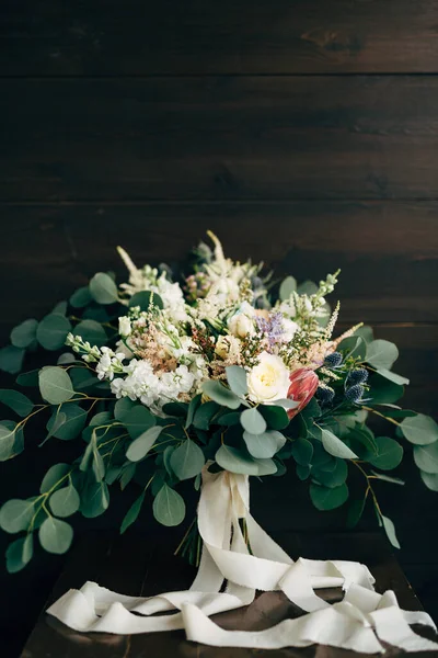 Ramo nupcial de rosas blancas y crema, ramas de eucalipto, protea, eringio, delphinium y cintas blancas —  Fotos de Stock