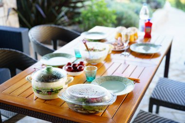 Bahçedeki aile yemeği için servis masası. Masada ızgara sebze, kebap ve salata var..