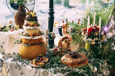 Festivaldeki büfe masası derme çatma bir peynirli kek. Masa zeytin dalları ve yapraklarla süslenmiş..