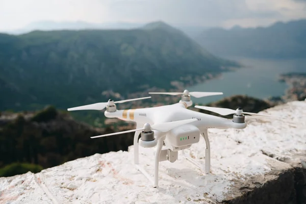 Un dron blanco se construye sobre una roca, listo para despegar . —  Fotos de Stock